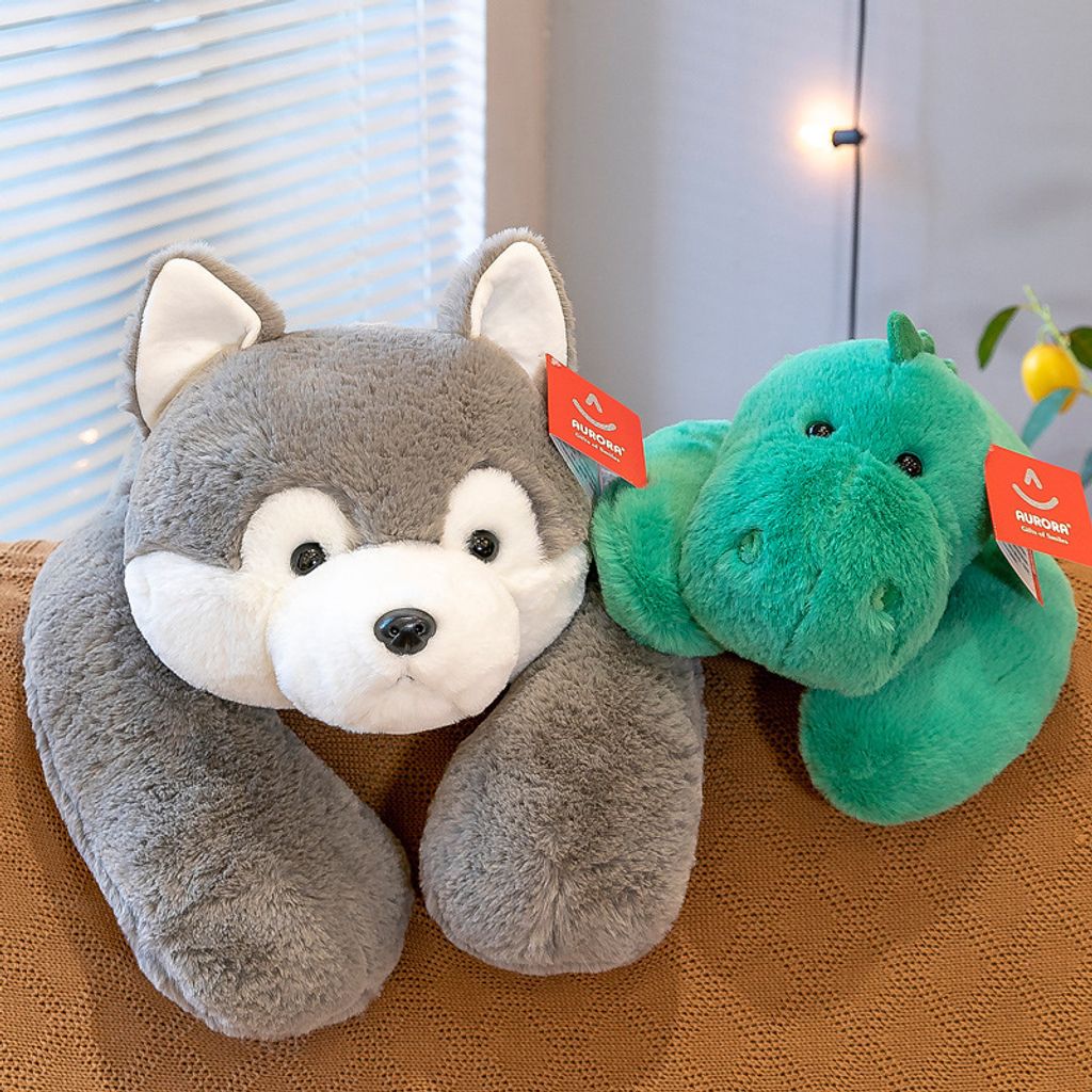 Husky and green dinosaur lying plush toys on a sofa