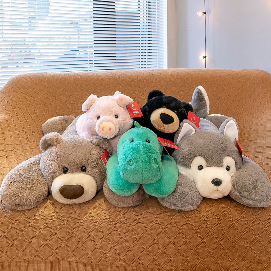 Animal lying plush toys arranged together on a sofa