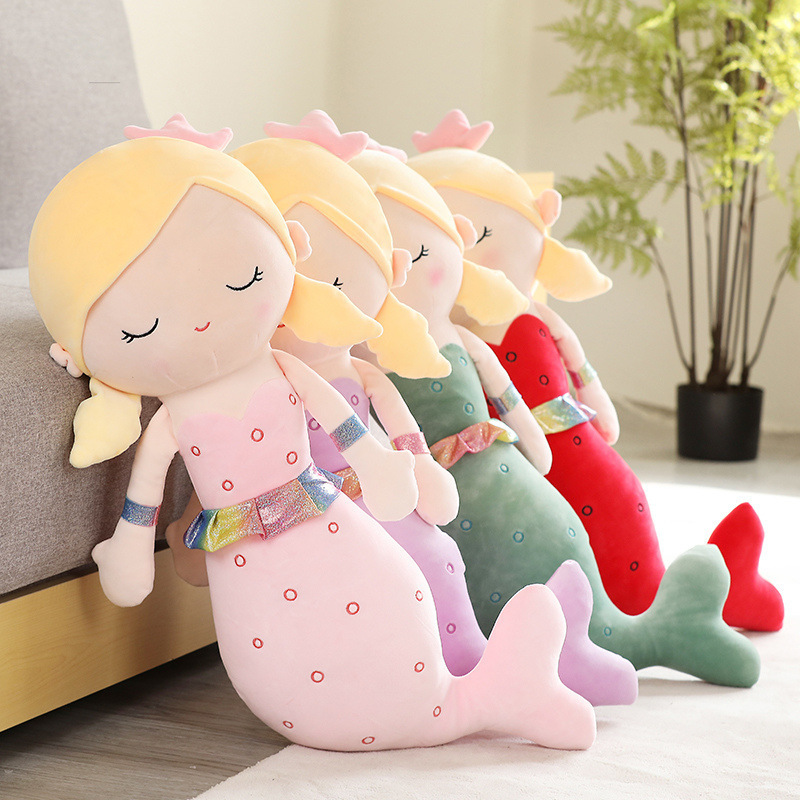 Cute mermaid plush toy in multiple colors displayed on sofa
