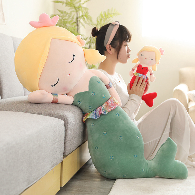 Cute mermaid plush toy leaning on sofa for hugging and relaxing