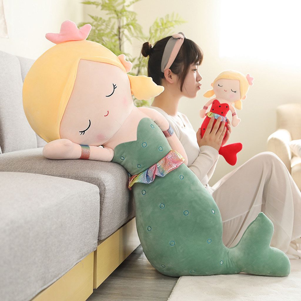 Cute mermaid plush toy leaning on sofa for hugging and relaxing