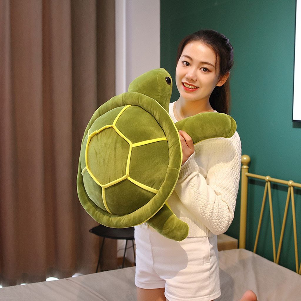 Giant turtle plush pillow held for size reference