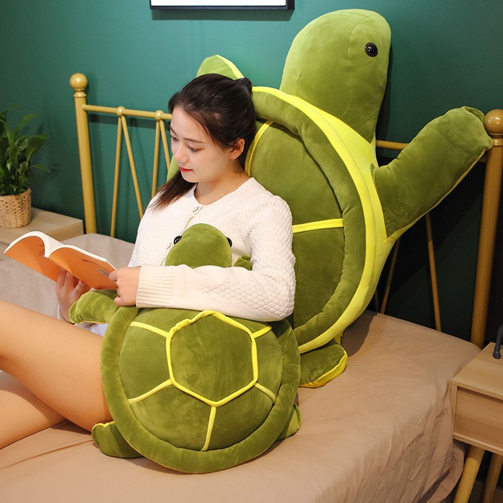 Giant turtle plush pillow for lounging and reading on a bed