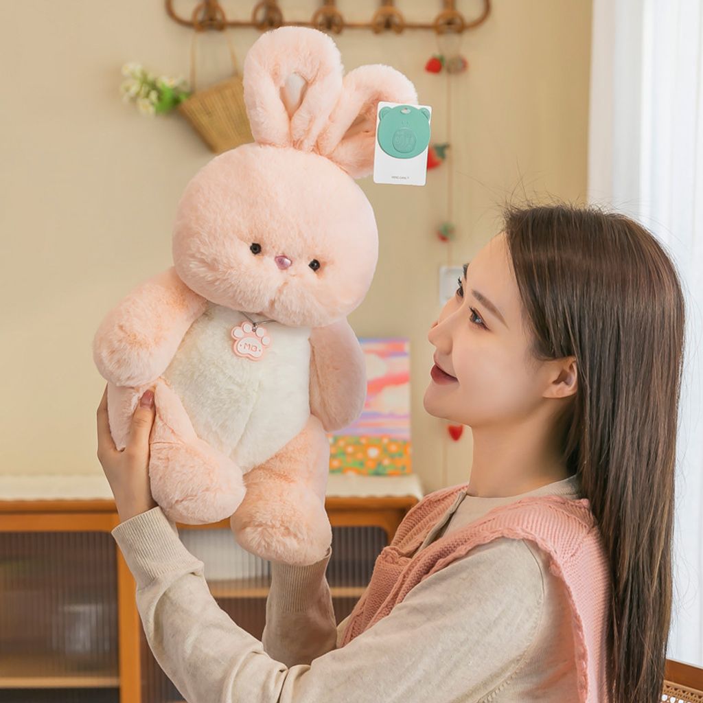Pink rabbit plush toy held up to show size and soft texture