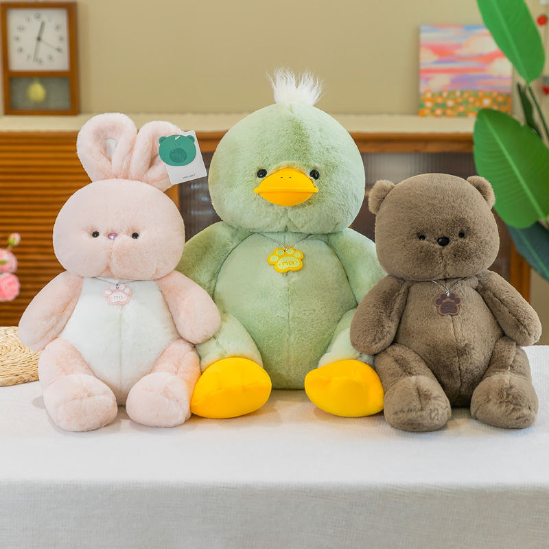 Pink rabbit green duck and brown bear plush toys displayed together