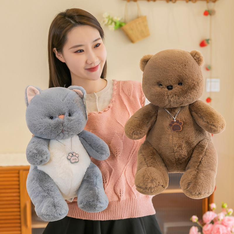 Gray cat and brown bear plush toys displayed side by side