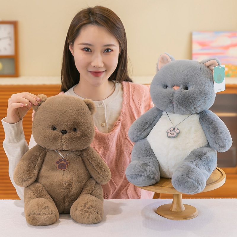 Brown bear and gray cat plush toys shown together in a cozy indoor setting