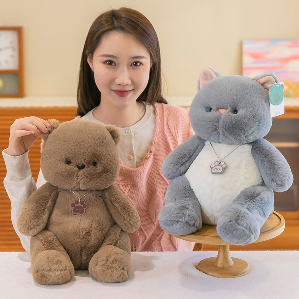 Brown bear and gray cat plush toys shown together in a cozy indoor setting