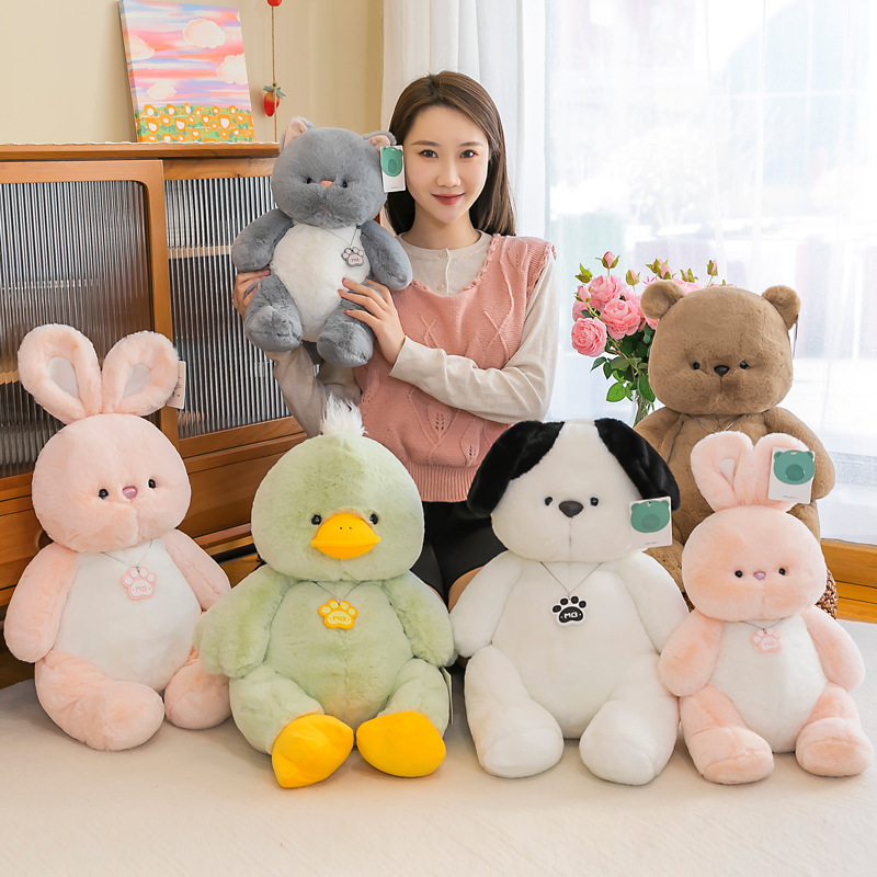 Bear cat dog rabbit and duck plush toys shown together in a cozy home setting
