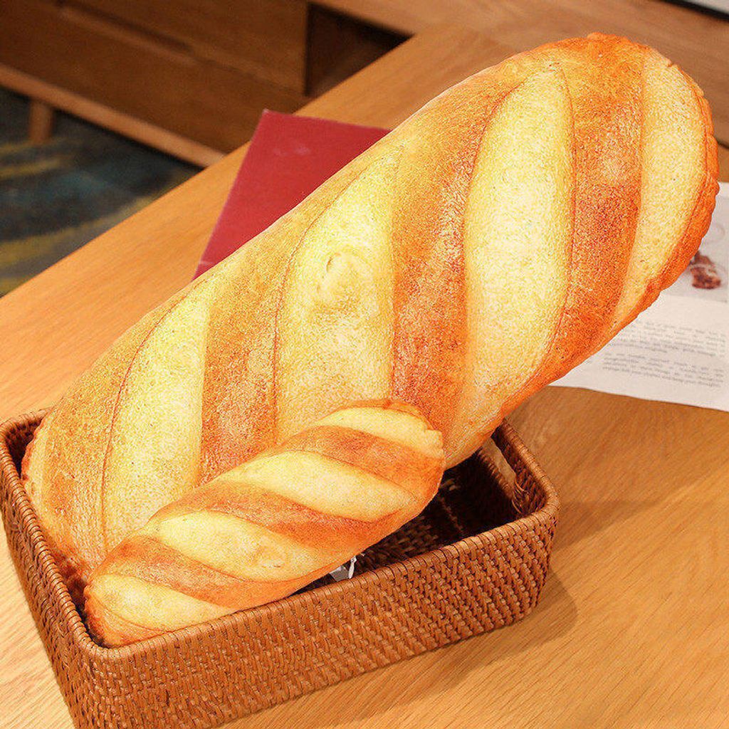 Realistic bread plush pillow displayed in a woven basket
