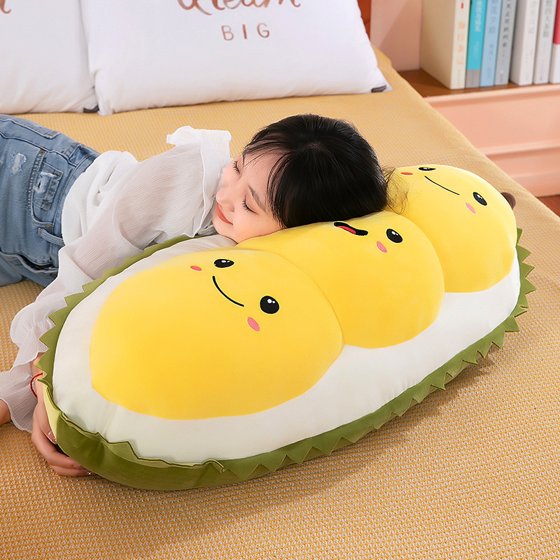 Cute durian plush pillow used as a body pillow for sleeping on bed