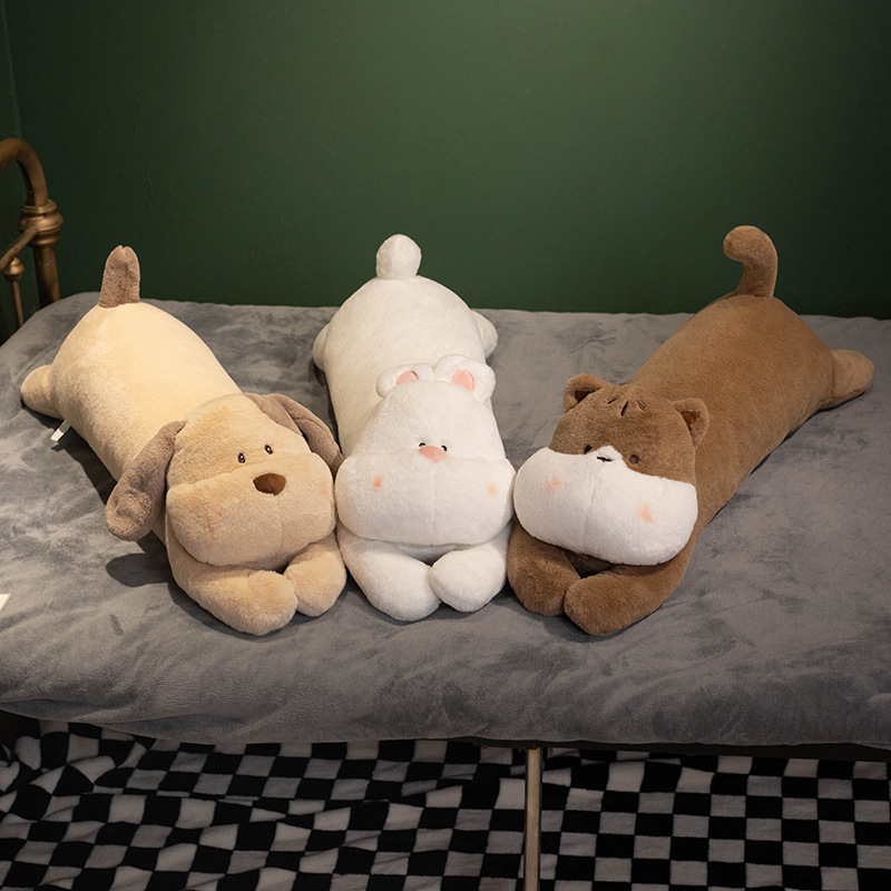 Cute lying dog, rabbit and cat plush pillows displayed together on bed