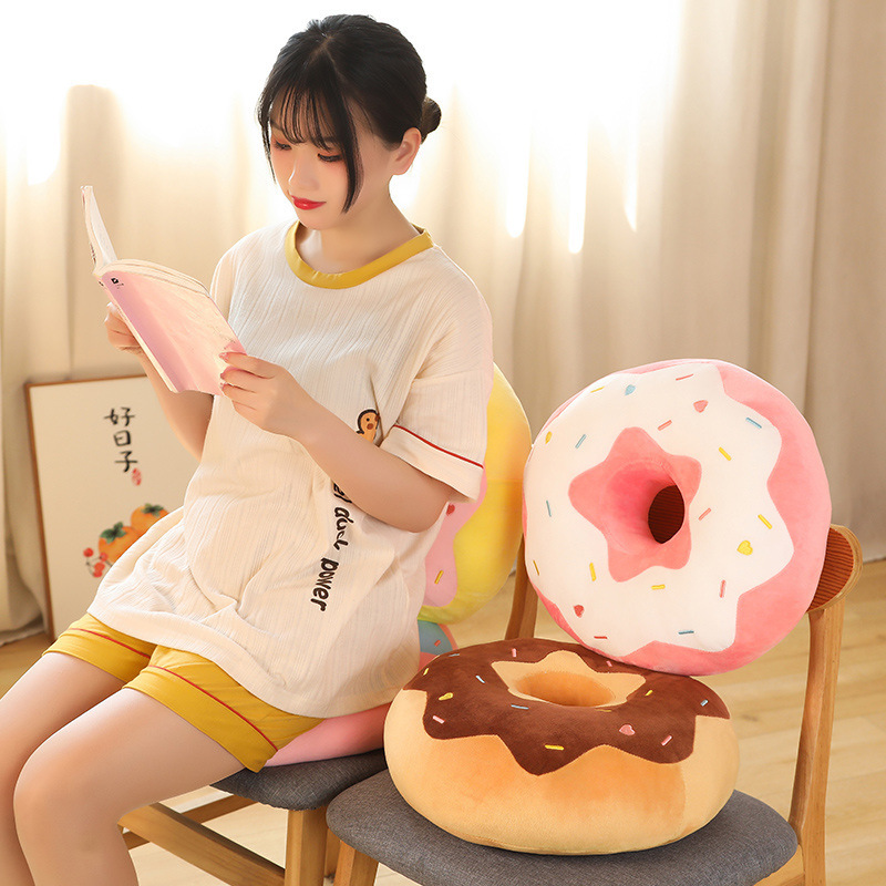 Donut plush pillow used as a back and seat cushion on a wooden chair