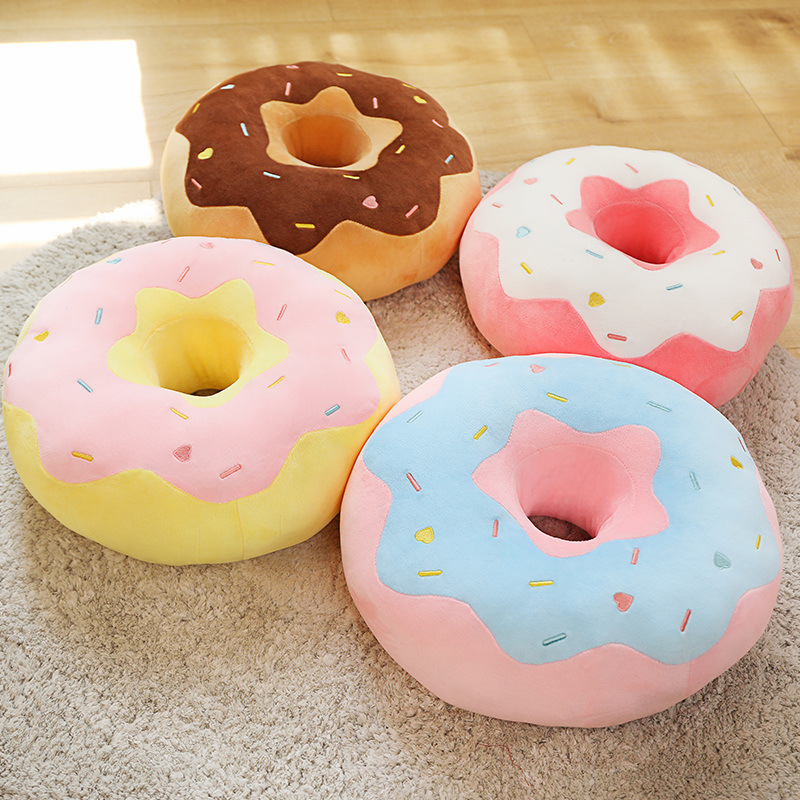 Donut plush pillow in pastel colors placed on a carpet