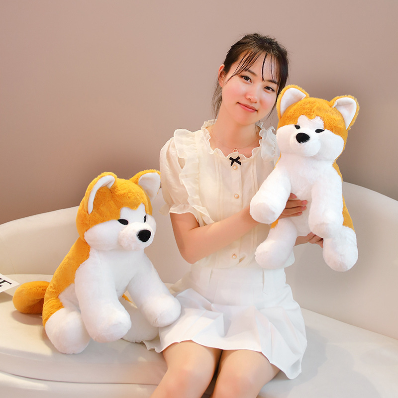 Cute Akita Inu sitting plush toys in different sizes on a sofa