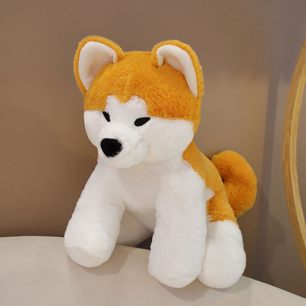 Cute Akita Inu sitting plush toy on a sofa