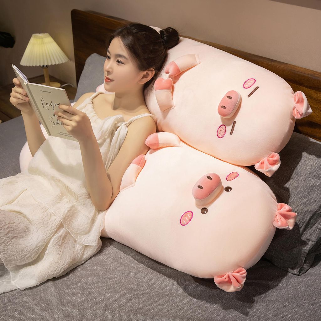 Cute pig long plush pillow used as a back support cushion for relaxing on the bed