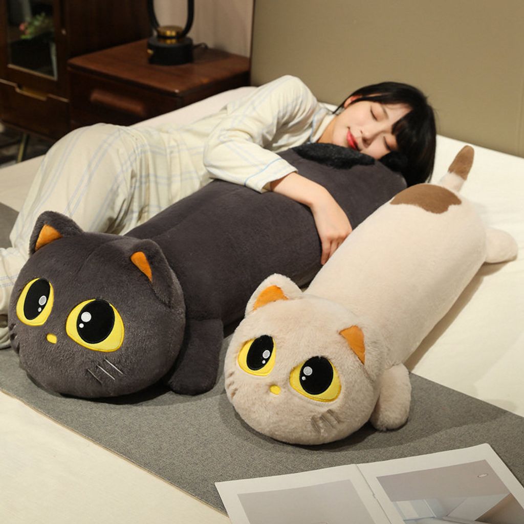 Cute lying cat long plush pillow used as a hugging body pillow on bed