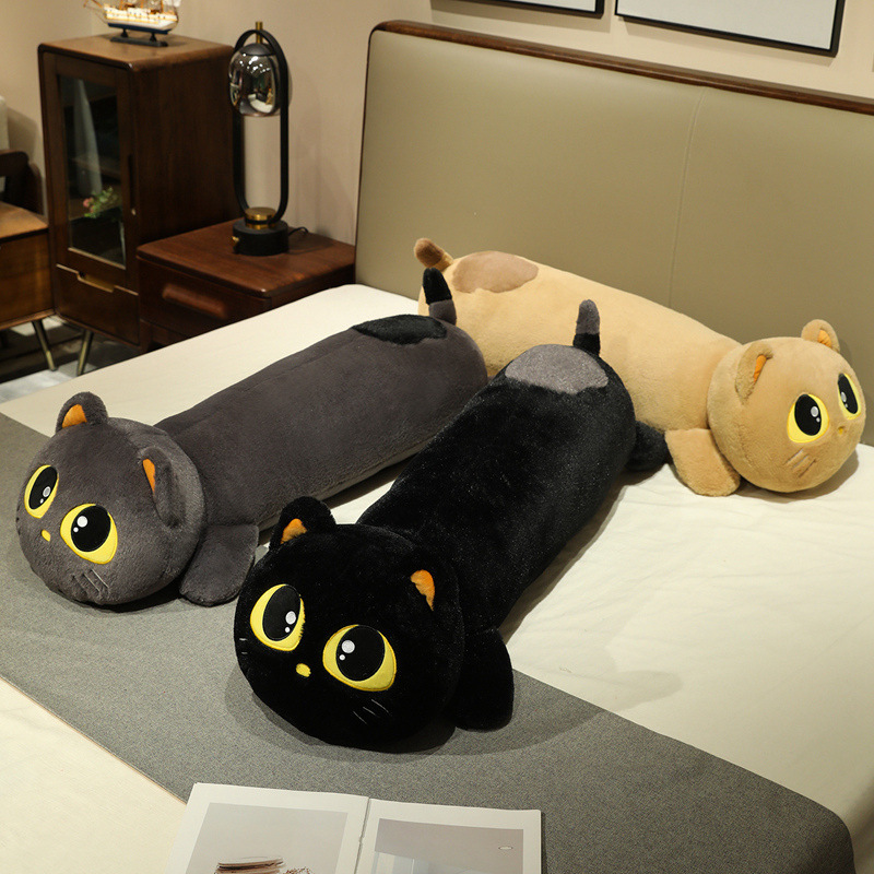 Black, gray, and brown cute lying cat long plush pillows on bed