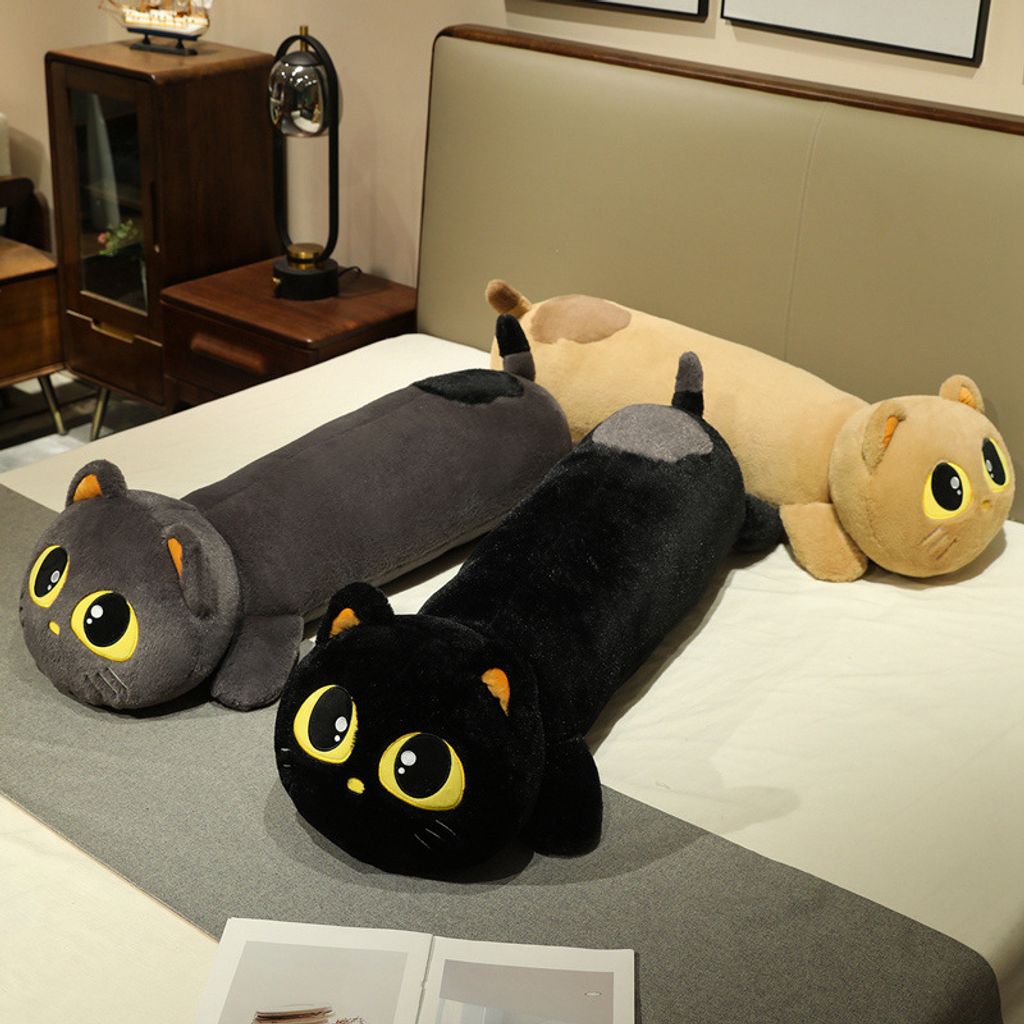Black, gray, and brown cute lying cat long plush pillows on bed