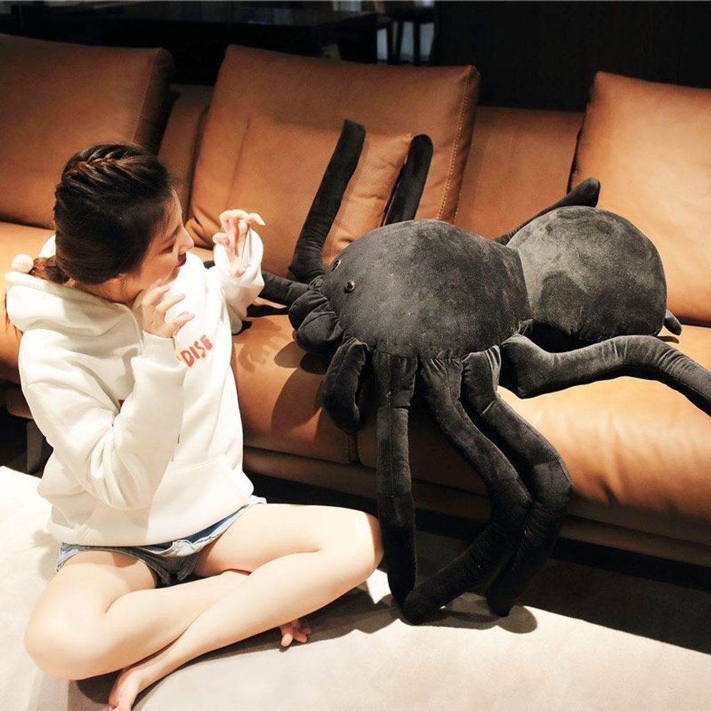 Giant spider plush pillow on sofa for size reference