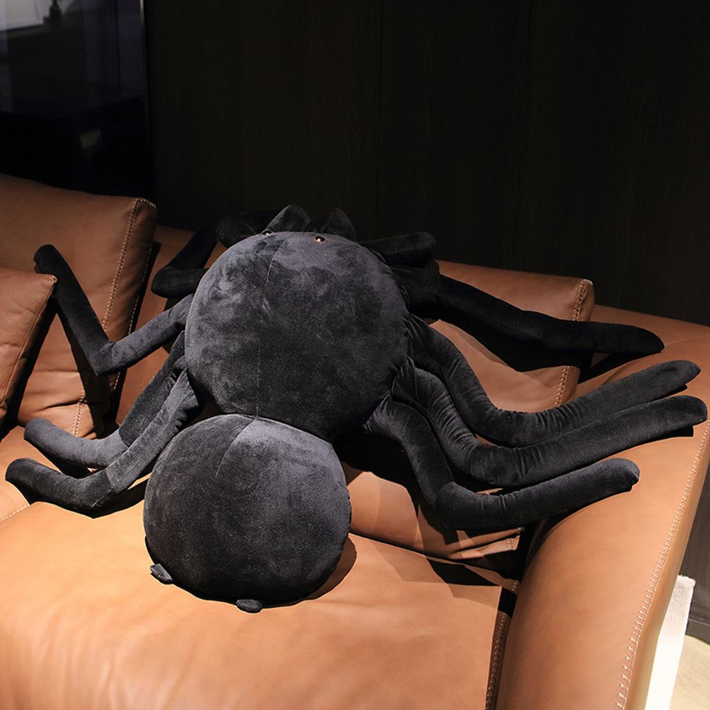 Giant spider plush pillow top view on sofa
