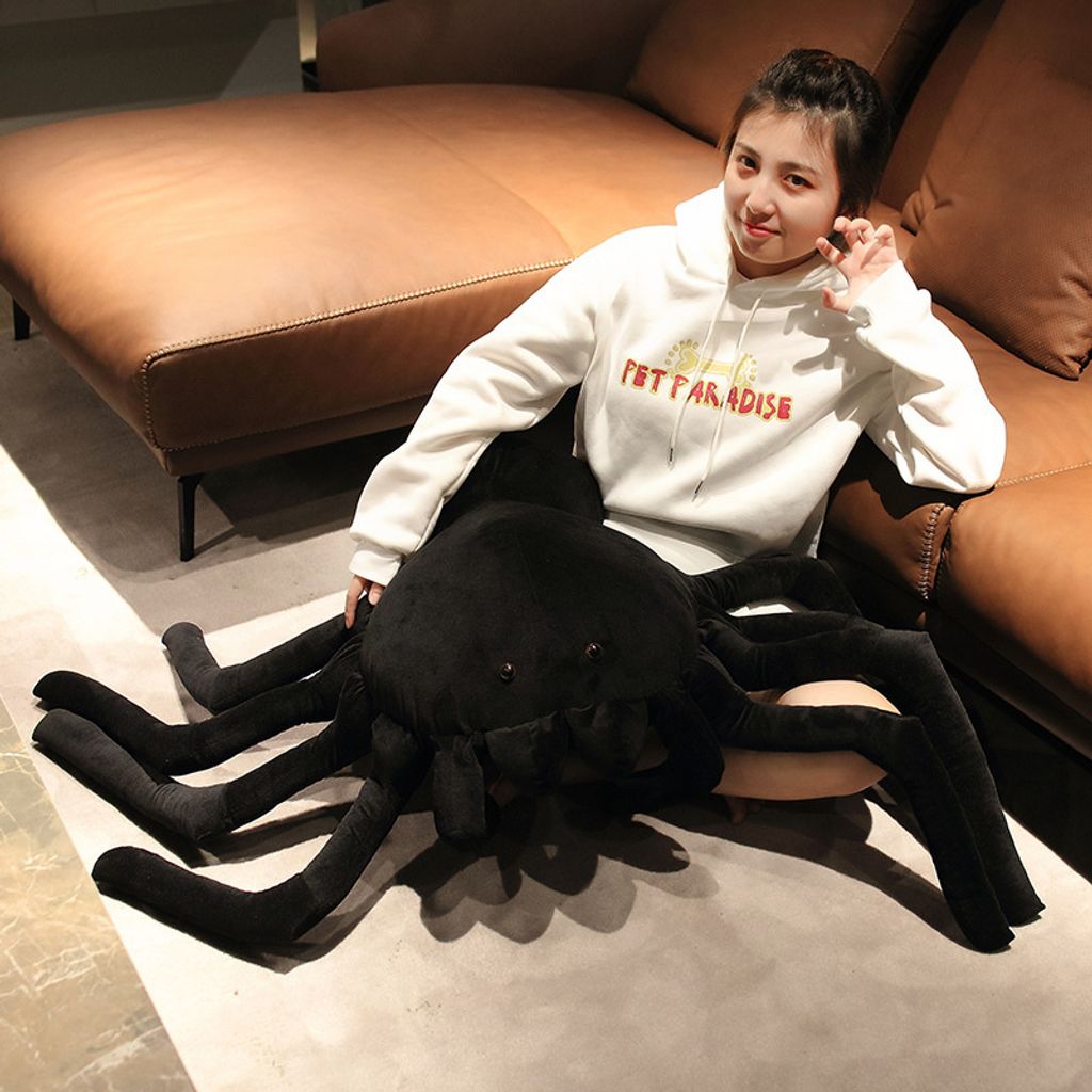 Giant spider plush pillow on floor for size reference
