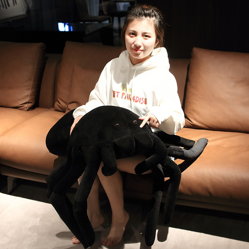 Giant spider plush pillow used as a soft cushion on sofa