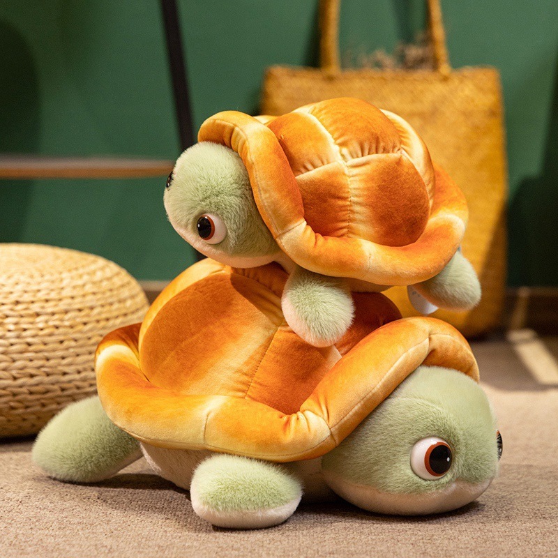 Two bread turtle plush toys stacked together with soft bread shells and green flippers on a cozy floor setting