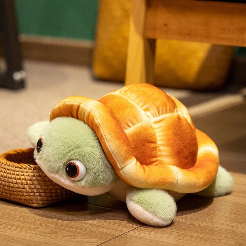 Bread turtle plush toy resting beside a woven basket, showing soft bread shell and green flippers