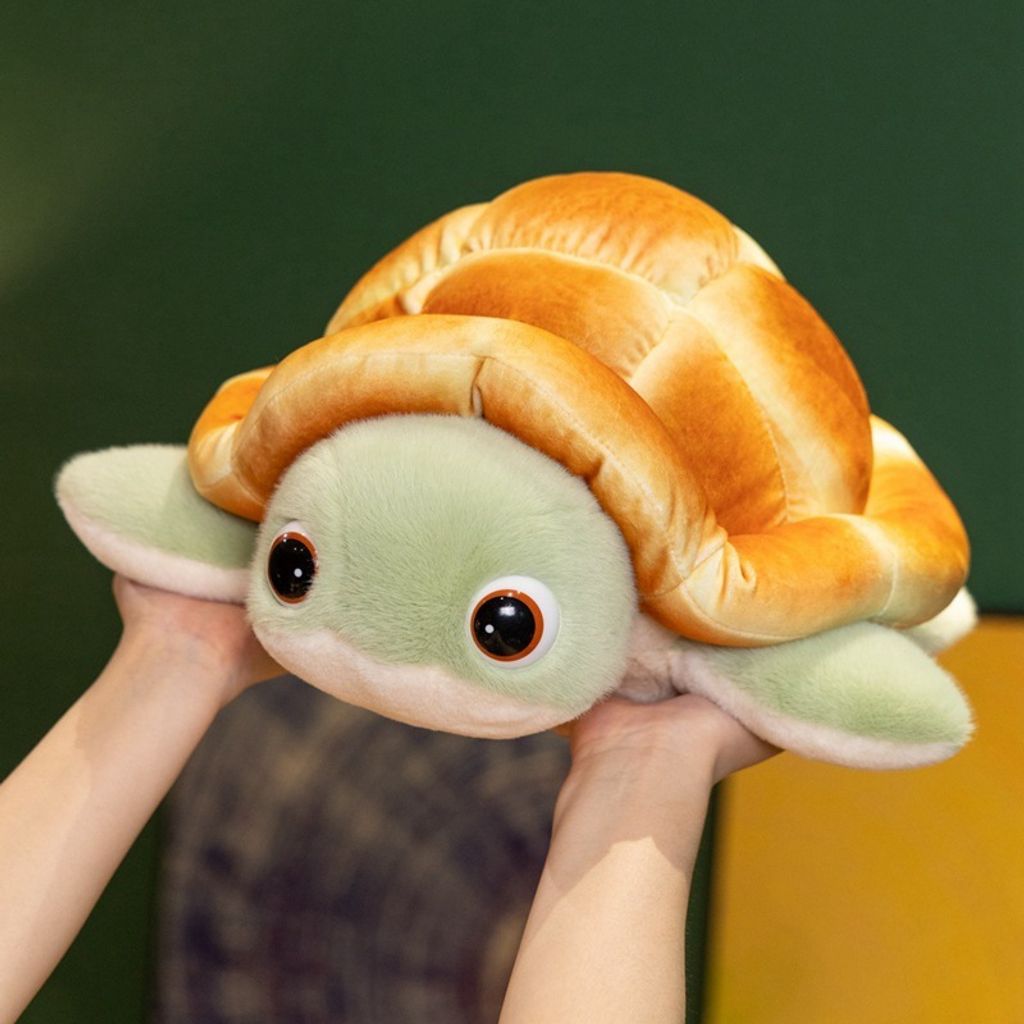 Bread turtle plush toy with round eyes, fluffy green flippers, and golden bread shell