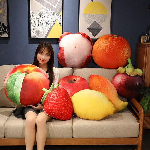 Realistic fruit plush pillows featuring nectarine, strawberry, lemon, apple, orange, and mangosteen on a sofa