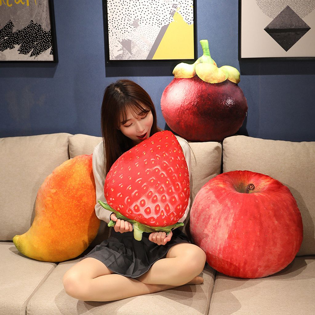 Strawberry plush pillow with realistic apple, mango, and mangosteen fruit cushions on a sofa