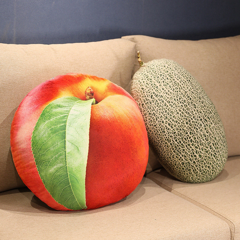 Realistic fruit plush pillows featuring nectarine and cantaloupe designs on a sofa