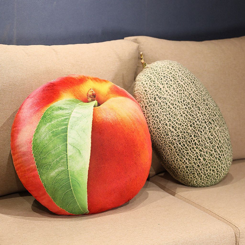 Realistic fruit plush pillows featuring nectarine and cantaloupe designs on a sofa