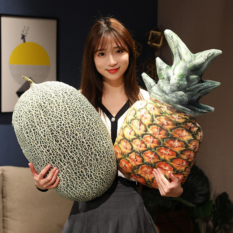 Realistic cantaloupe and pineapple plush pillows shown in a cozy indoor setting