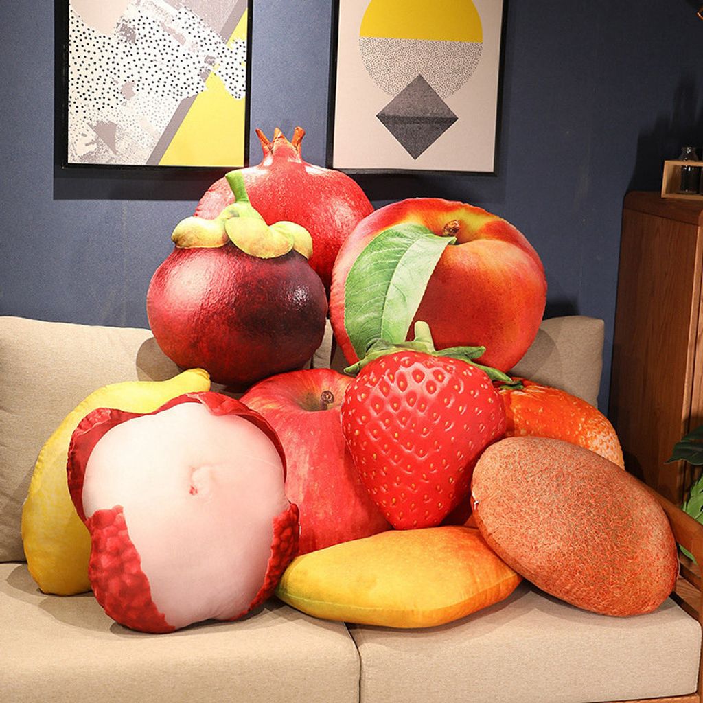 Realistic fruit plush pillows on a sofa featuring strawberry, apple, lemon, mango, pomegranate, and orange