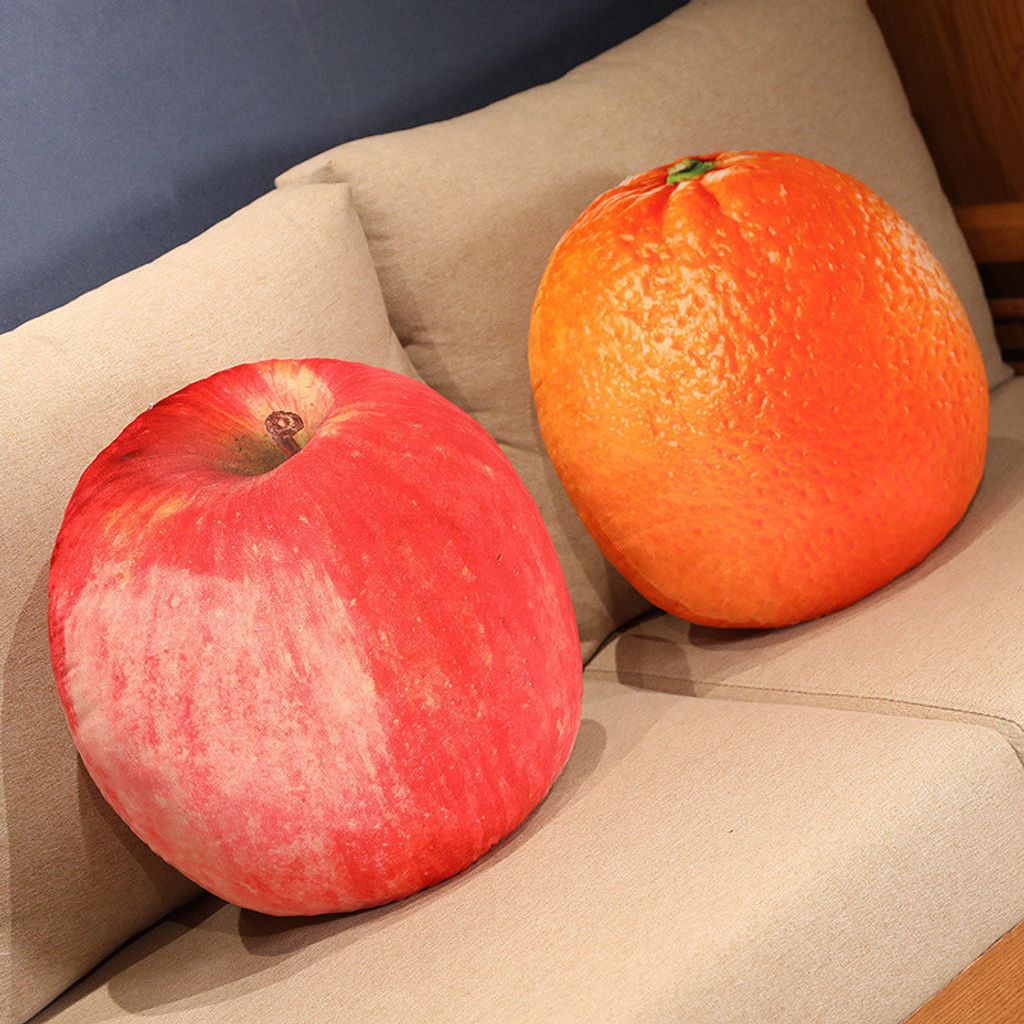 Realistic fruit plush pillows featuring apple and orange designs on a sofa