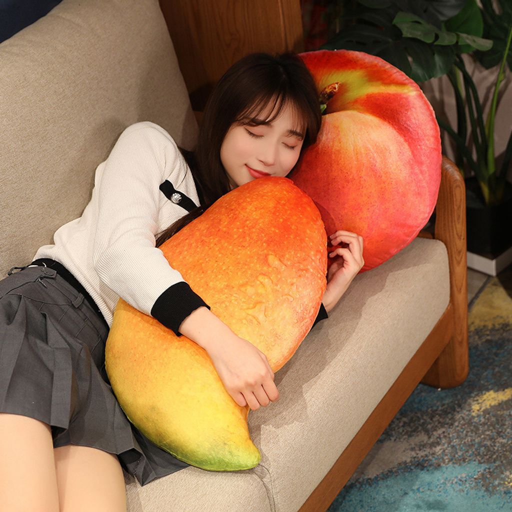 Realistic mango and apple plush pillows displayed as soft fruit cushions on a living room sofa