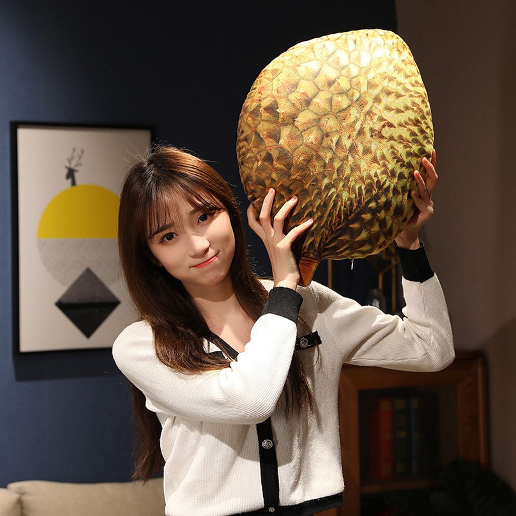 Realistic durian plush pillow with textured spiky design shown in a cozy indoor setting