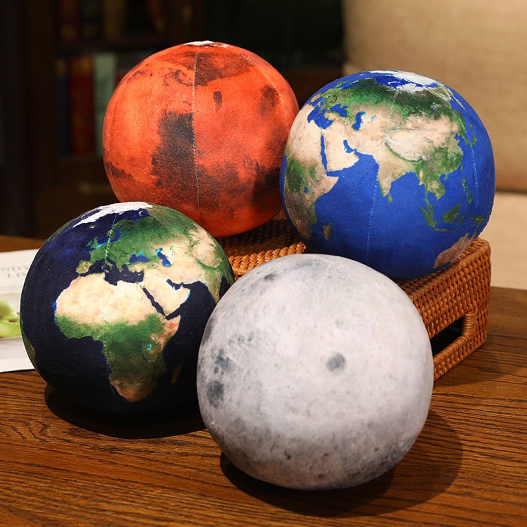 Earth, Mars and Moon planet plush pillows on wooden table