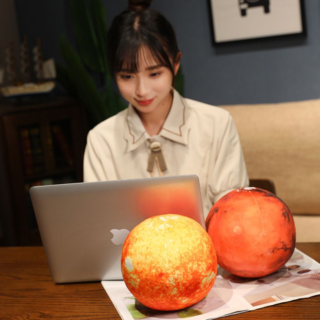 Sun and Mars planet plush pillows on wooden table