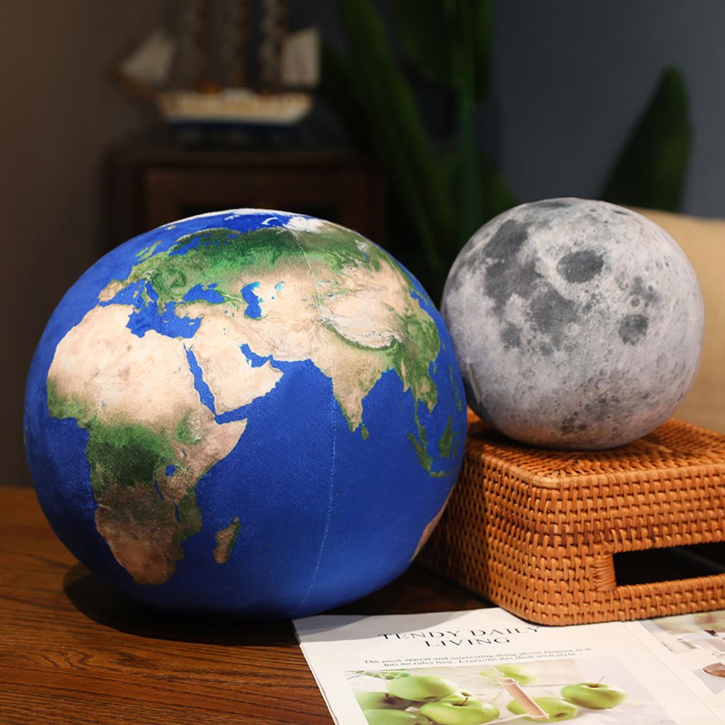 Earth and Moon planet plush pillows displayed on wooden table