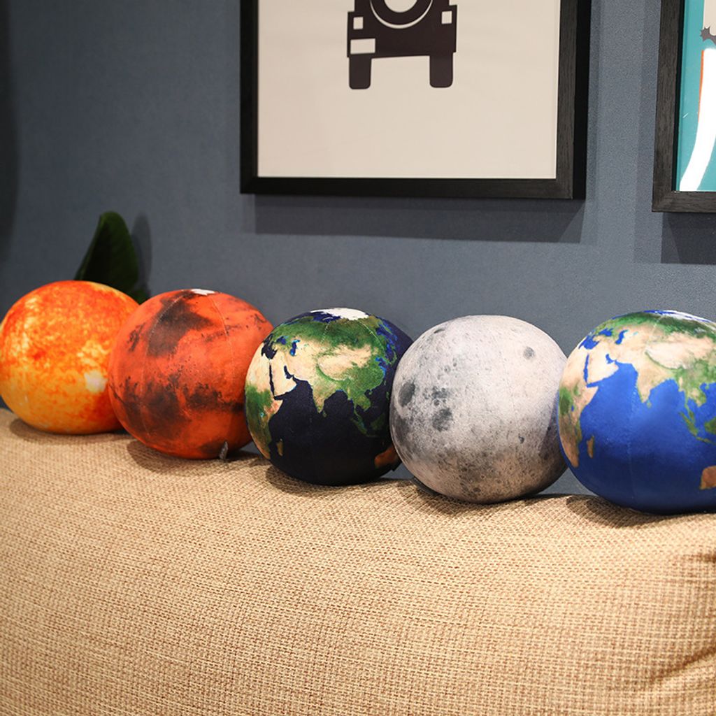 Planet plush pillows lined up on sofa