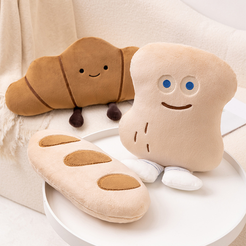 Close-up of Croissant and Peanut Bun plush pillows with soft fabric and cute facial details