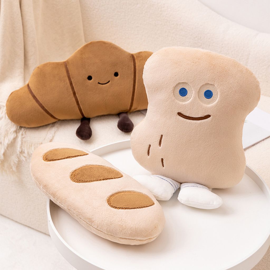 Close-up of Croissant and Peanut Bun plush pillows with soft fabric and cute facial details