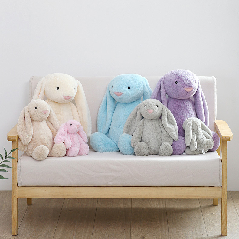 Cute lop ear bunny plush toys in different colors and sizes on a wooden sofa