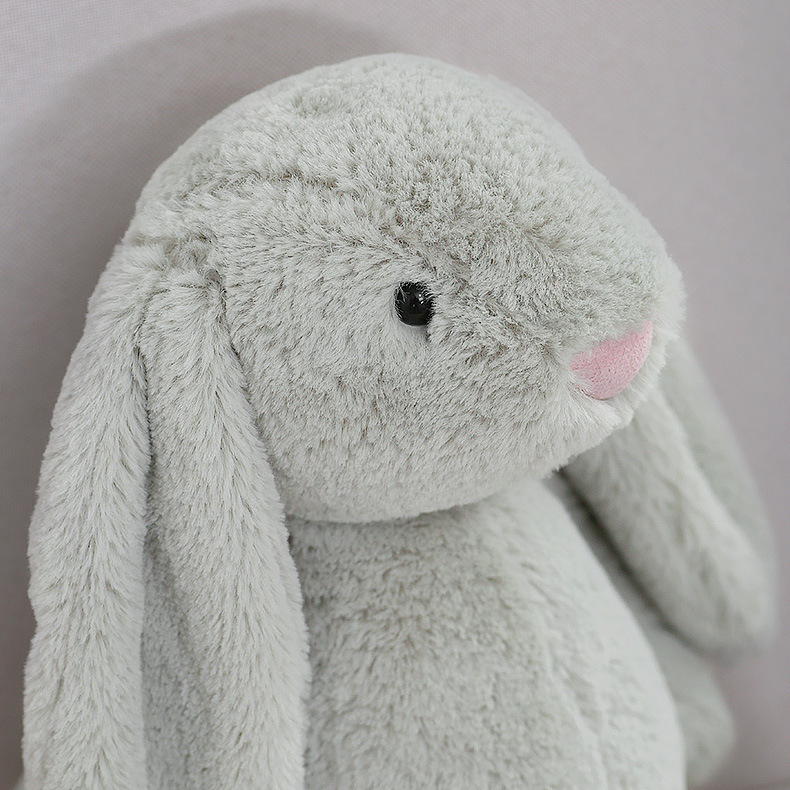 Close up of gray lop ear bunny plush toy face with floppy ears