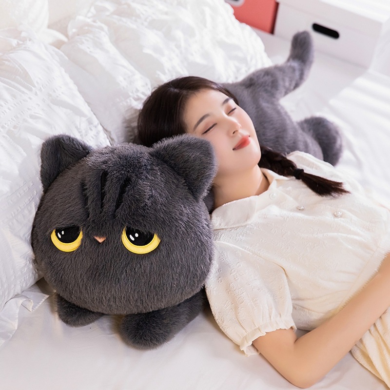 Gray lying cat plush pillow used for relaxing and sleeping on a bed