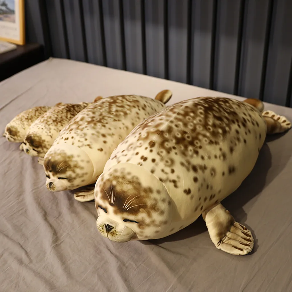 Seal plush pillows arranged on bed showing different size options